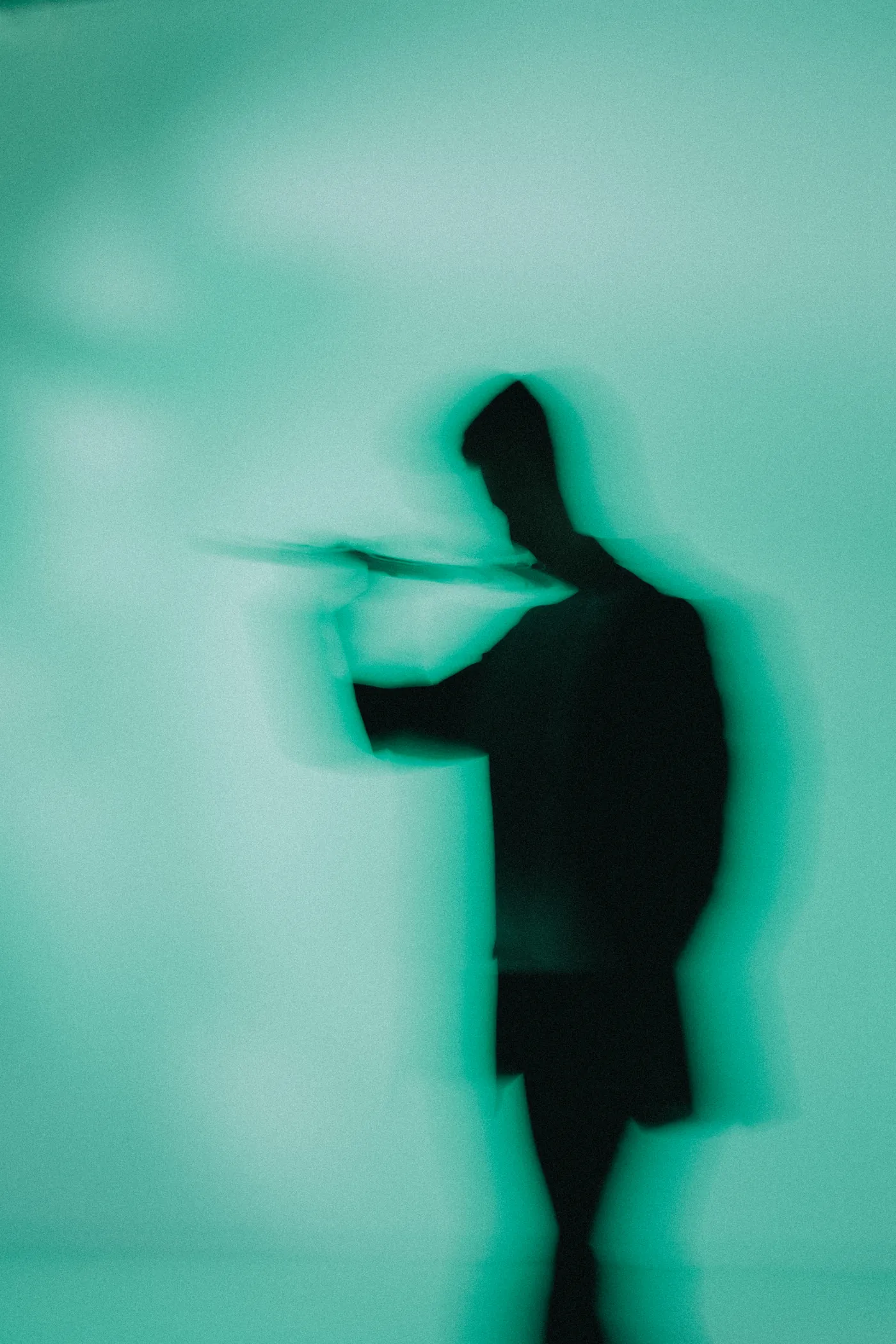 Blurred silhouette of Alberto Acuña playing the flute in green light