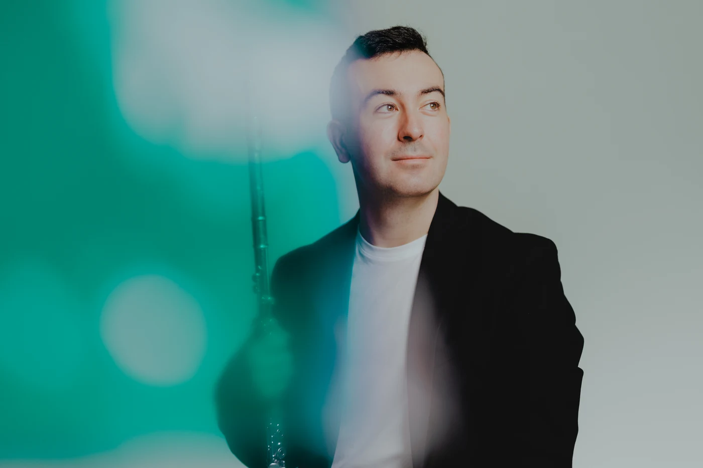 Alberto Acuña photographed in the studio, flute in hand, against a green haze